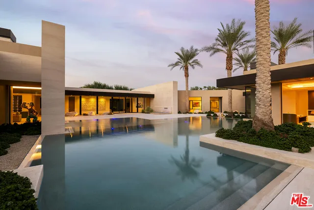 a view of a swimming pool with a chair and palm trees