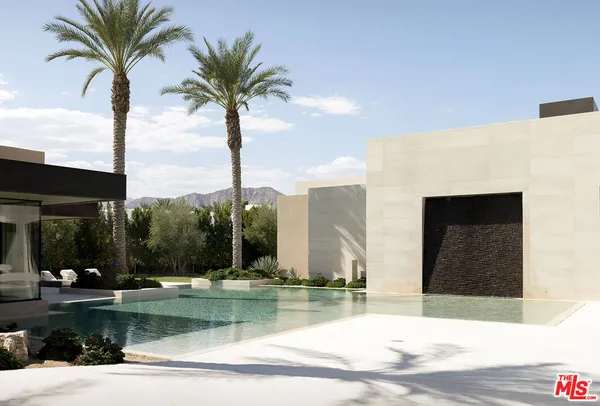 a living room with patio furniture and a floor to ceiling window