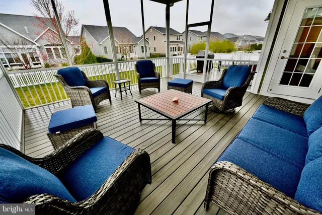 a view of a rooftop deck with couch and chairs