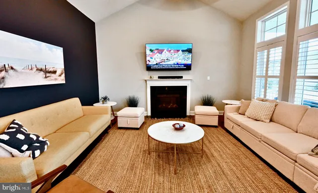 a living room with furniture a fireplace and a large window