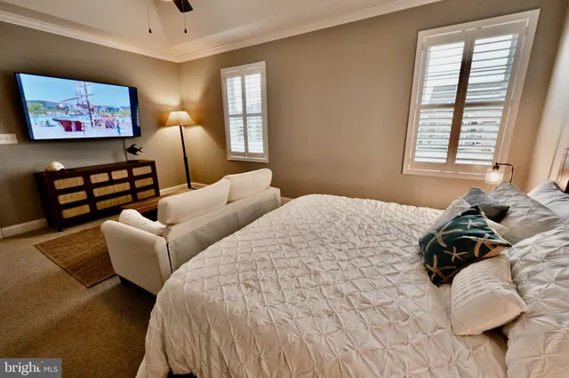 a bedroom with two beds and a large mirror next to a window