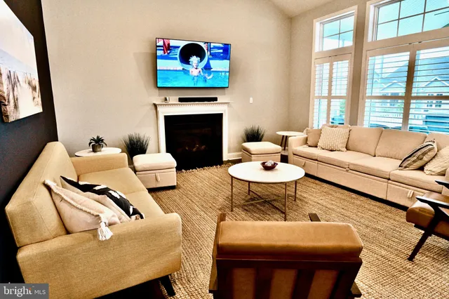 a living room with furniture a large window and a fireplace