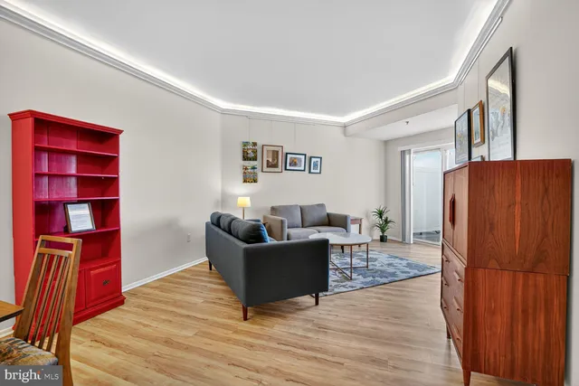 a living room with furniture cabinets and wooden floor