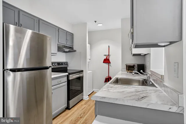 a kitchen with refrigerator a stove and a sink
