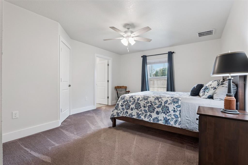 1049 Pinder Street Deltona, FL 32725 - Photo 11 of 20 a bedroom with a bed and a chandelier