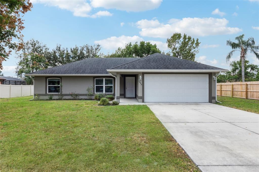 1049 Pinder Street Deltona, FL 32725 - Photo 2 of 20 a front view of a house with garden