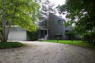 a view of a house with a yard and large tree