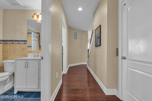 a spacious bedroom with a bed and wooden floor