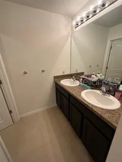 a bathroom with a double vanity sink and a mirror