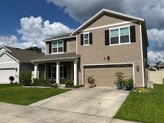 a front view of a house with a yard and garage