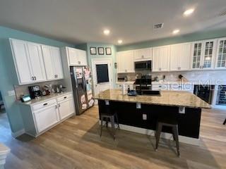 5911 Southwest 84th Street Gainesville, FL 32608 - Photo 3 of 30 a kitchen with stainless steel appliances granite countertop a stove a sink dishwasher and a refrigerator with wooden floor
