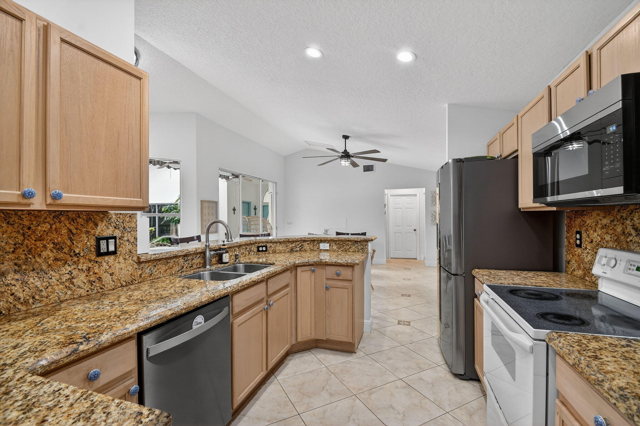 2769 Pointe Circle Greenacres, FL 33413 - Photo 15 of 48 a kitchen with stainless steel appliances granite countertop a sink stove and refrigerator