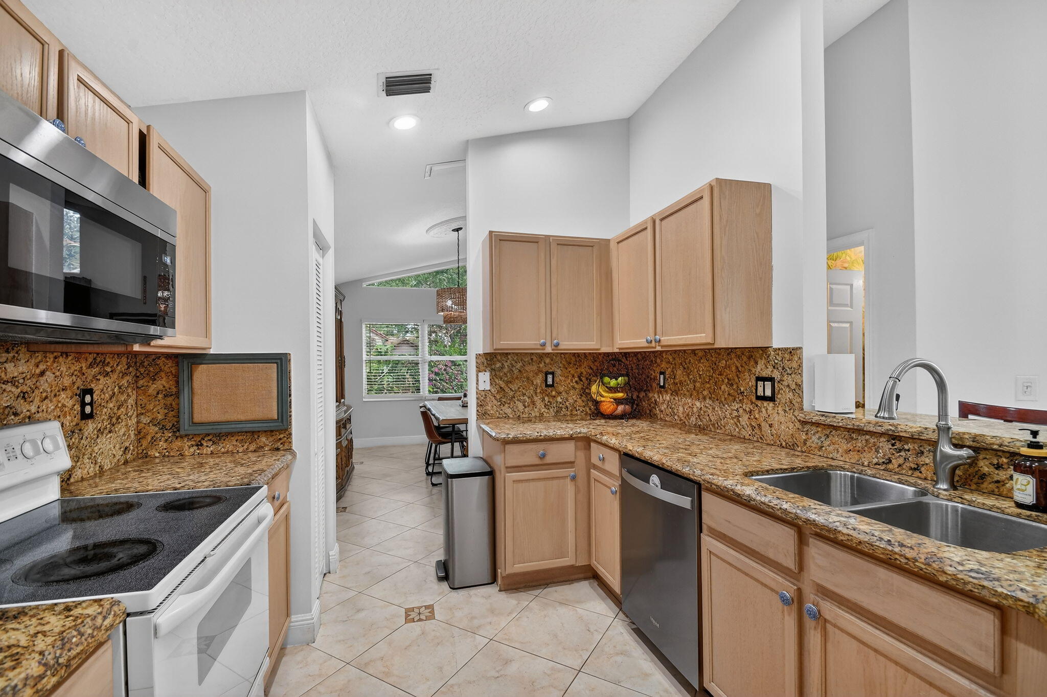 2769 Pointe Circle Greenacres, FL 33413 - Photo 16 of 48 a kitchen with stainless steel appliances granite countertop a sink stove and cabinets