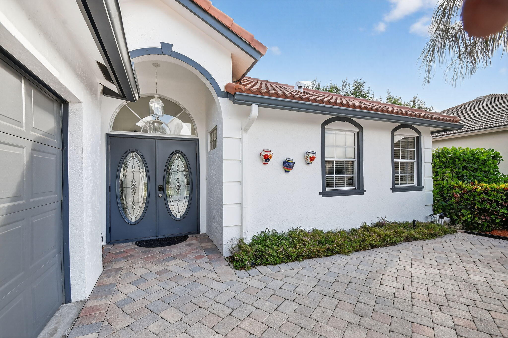2769 Pointe Circle Greenacres, FL 33413 - Photo 2 of 48 a front view of a house with garden