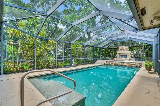 a view of a swimming pool with a patio and a yard