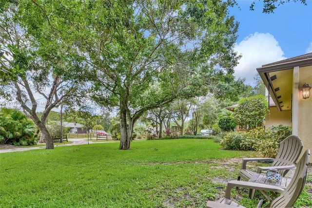 a view of backyard with huge green area and large trees