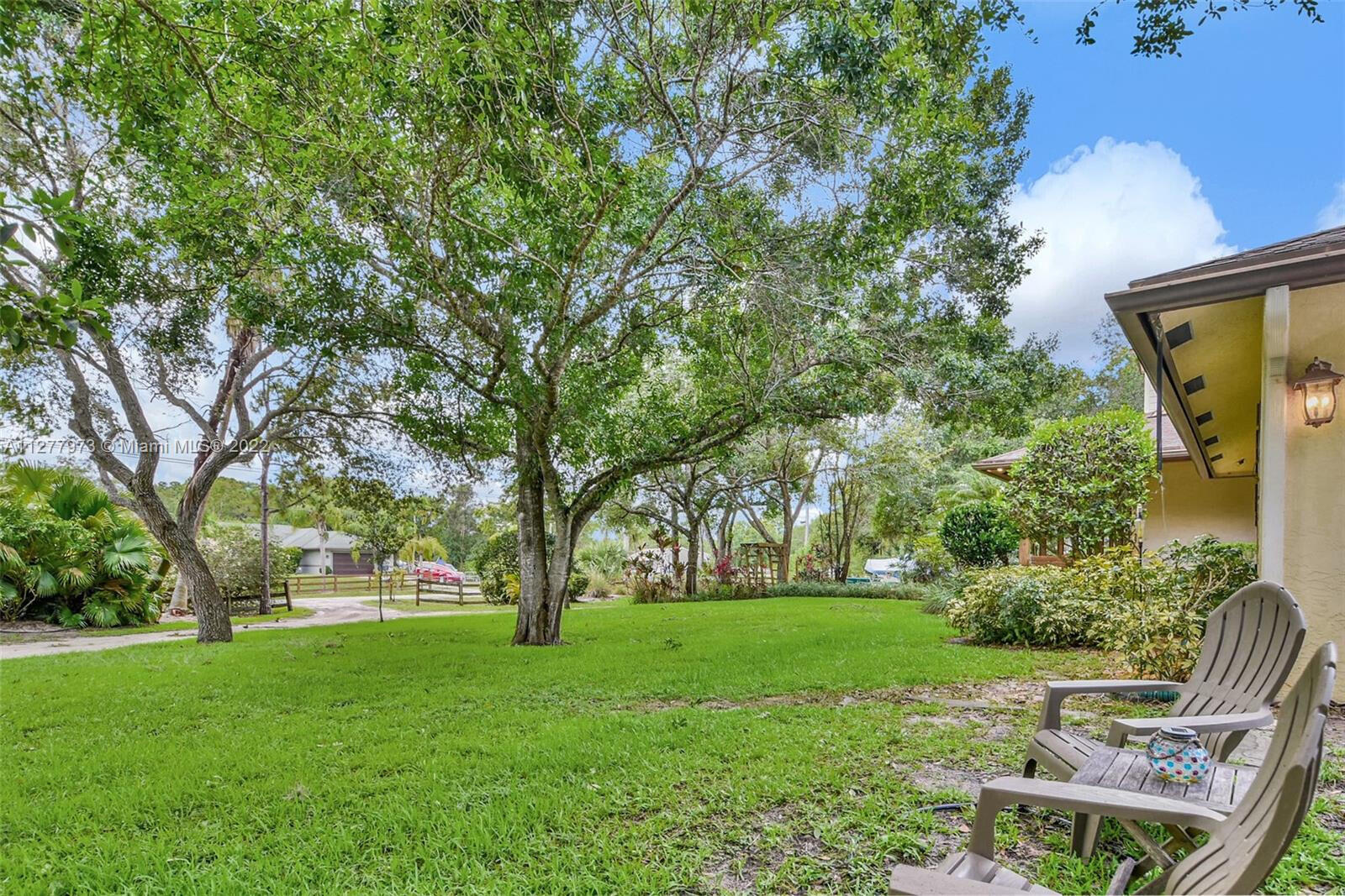 14425 North 64th Court North Loxahatchee, FL 33470 - Photo 10 of 36 a view of backyard with huge green area and large trees