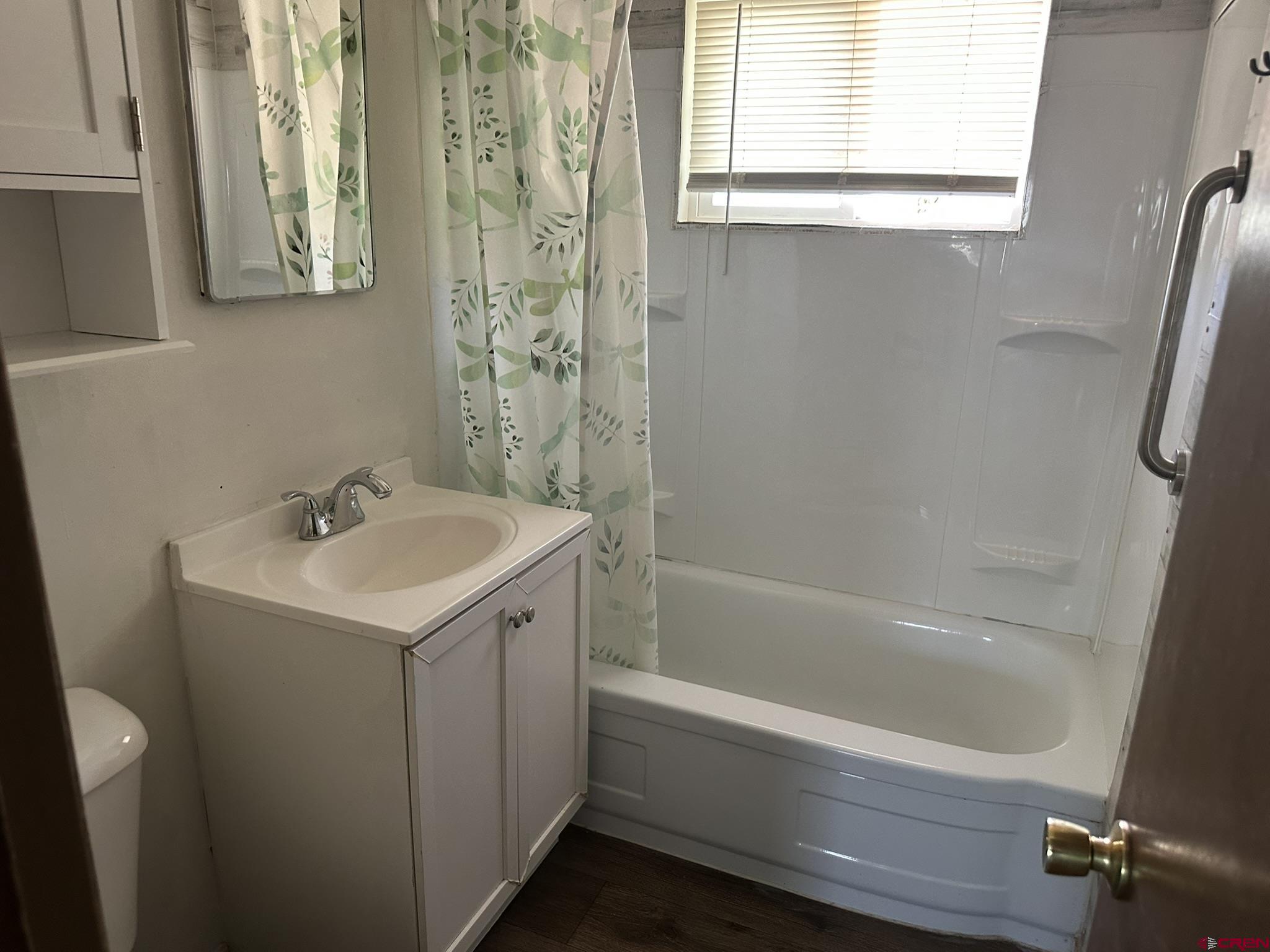 435 South Elm Street Cortez, CO 81321 - Photo 9 of 17 a bathroom with a sink a mirror and a bathtub