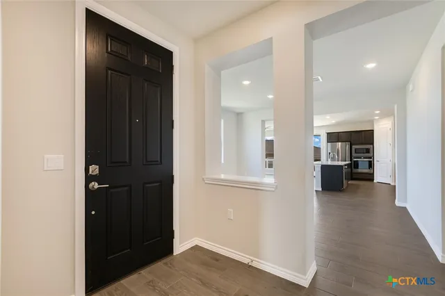 a living room with stainless steel appliances kitchen island wooden floors and view living room
