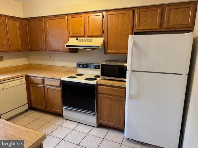 a kitchen with stainless steel appliances granite countertop a refrigerator a stove a sink and dishwasher