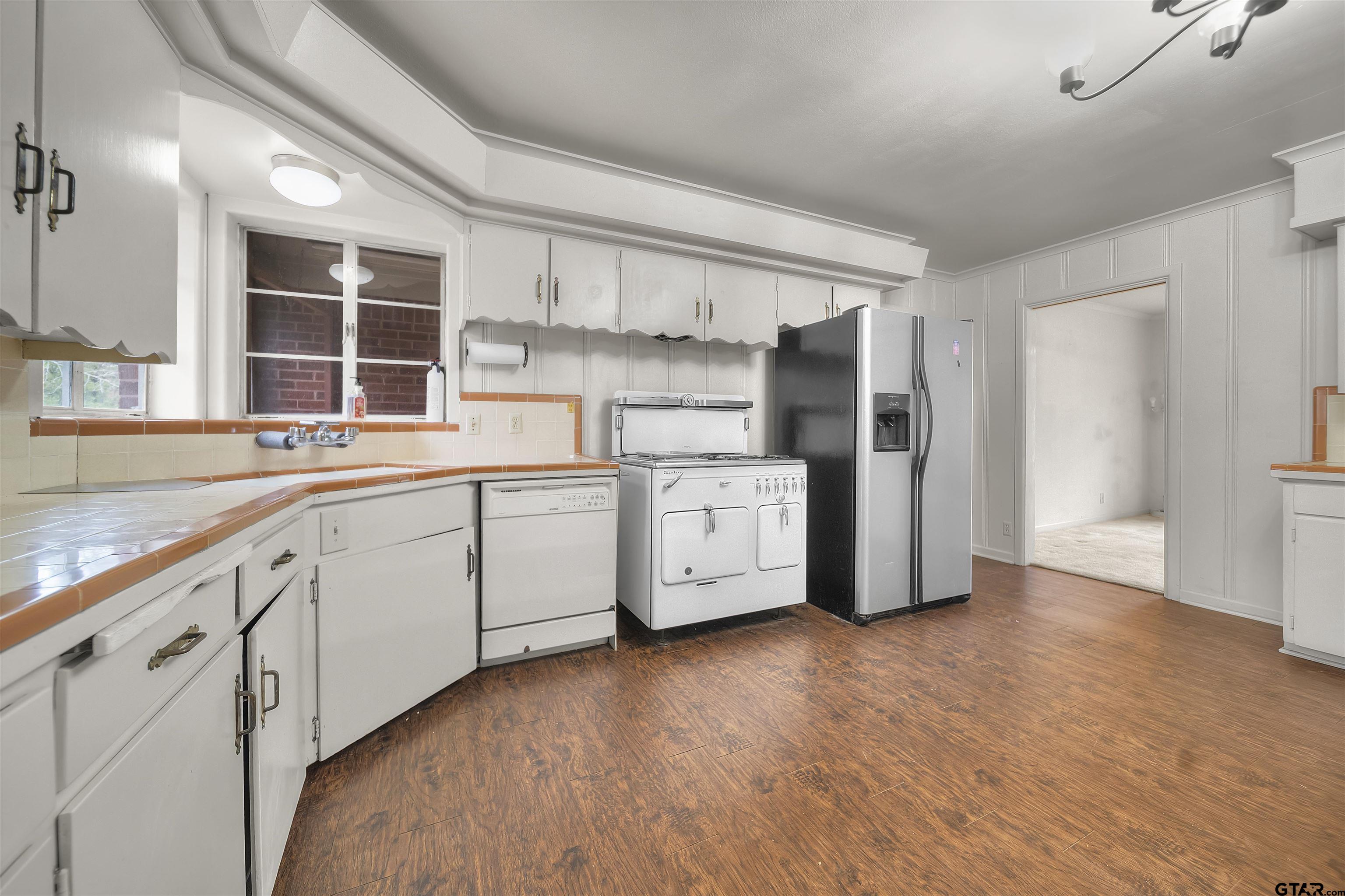 2521 Pounds Tyler, TX 75701 - Photo 8 of 40 a kitchen with white cabinets and wooden floor