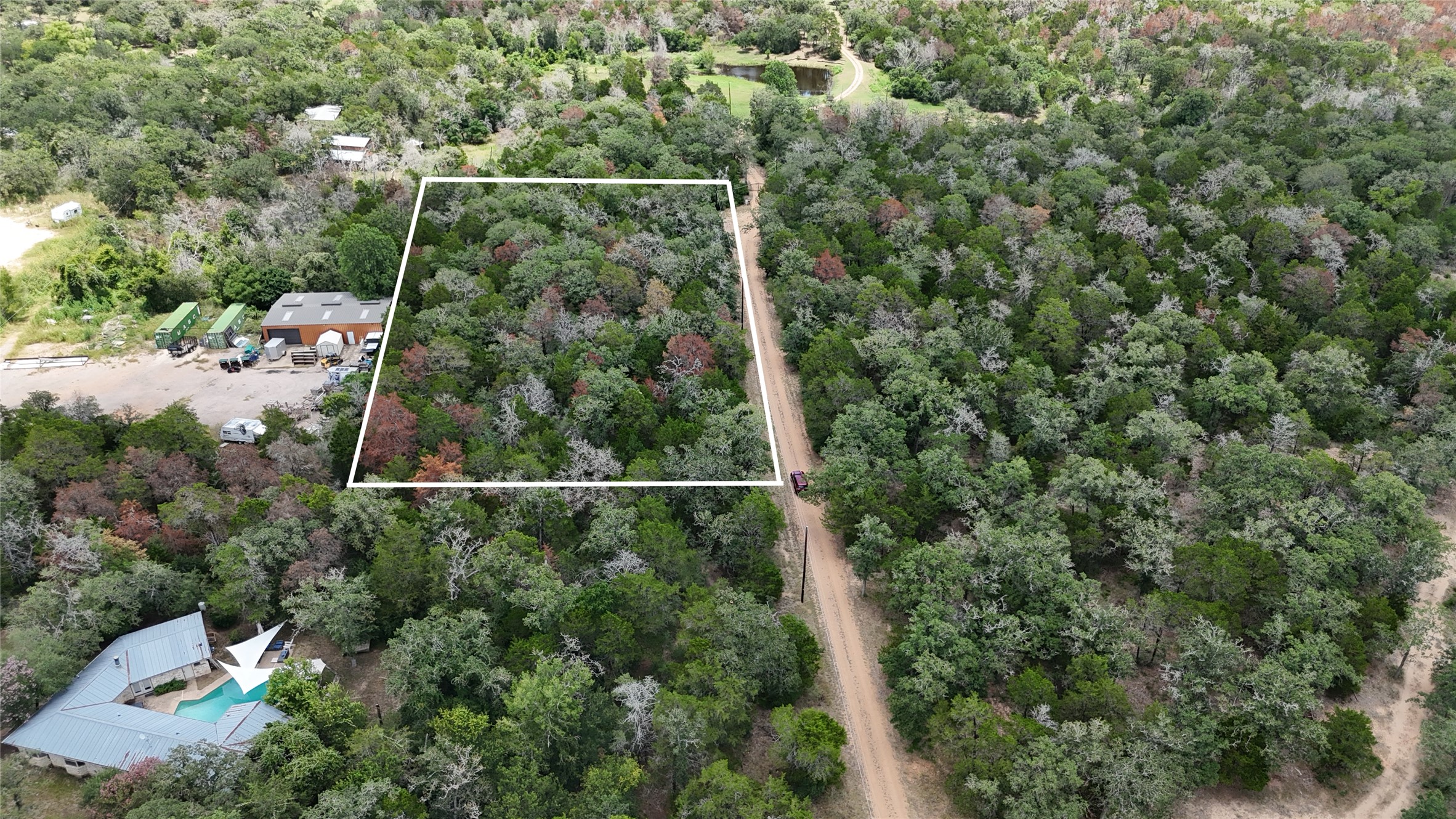 Tbd Red Fox Lane Bastrop, TX 78602 - Photo 7 of 14 A tranquil, tree-lined rural lot awaits, offering privacy and a verdant natural setting.
