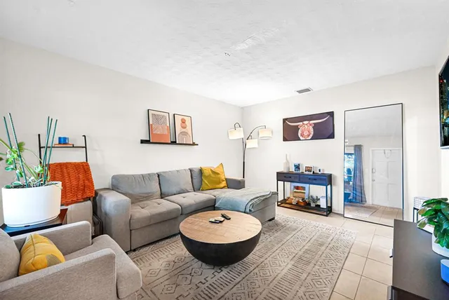 a living room with furniture and a potted plant