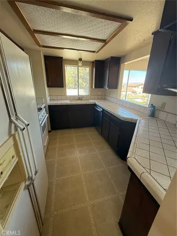 a kitchen with a sink a stove top oven and cabinetry