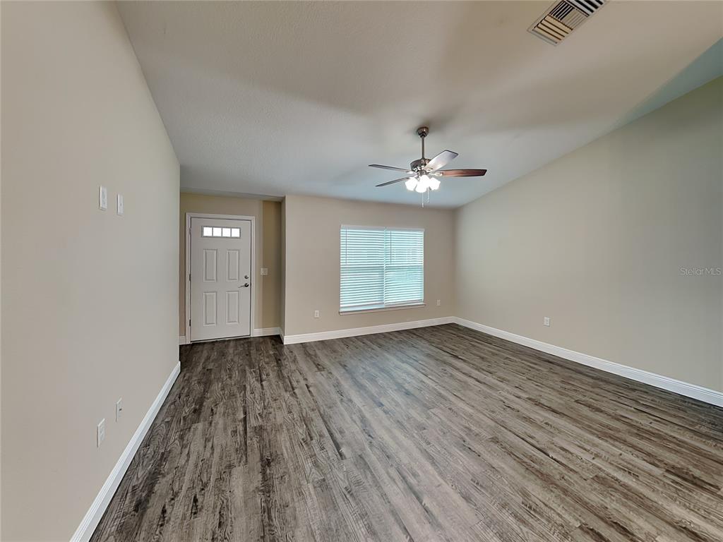 904 West Rum Place Dunnellon, FL 34434 - Photo 2 of 15 wooden floor in an empty room with a window