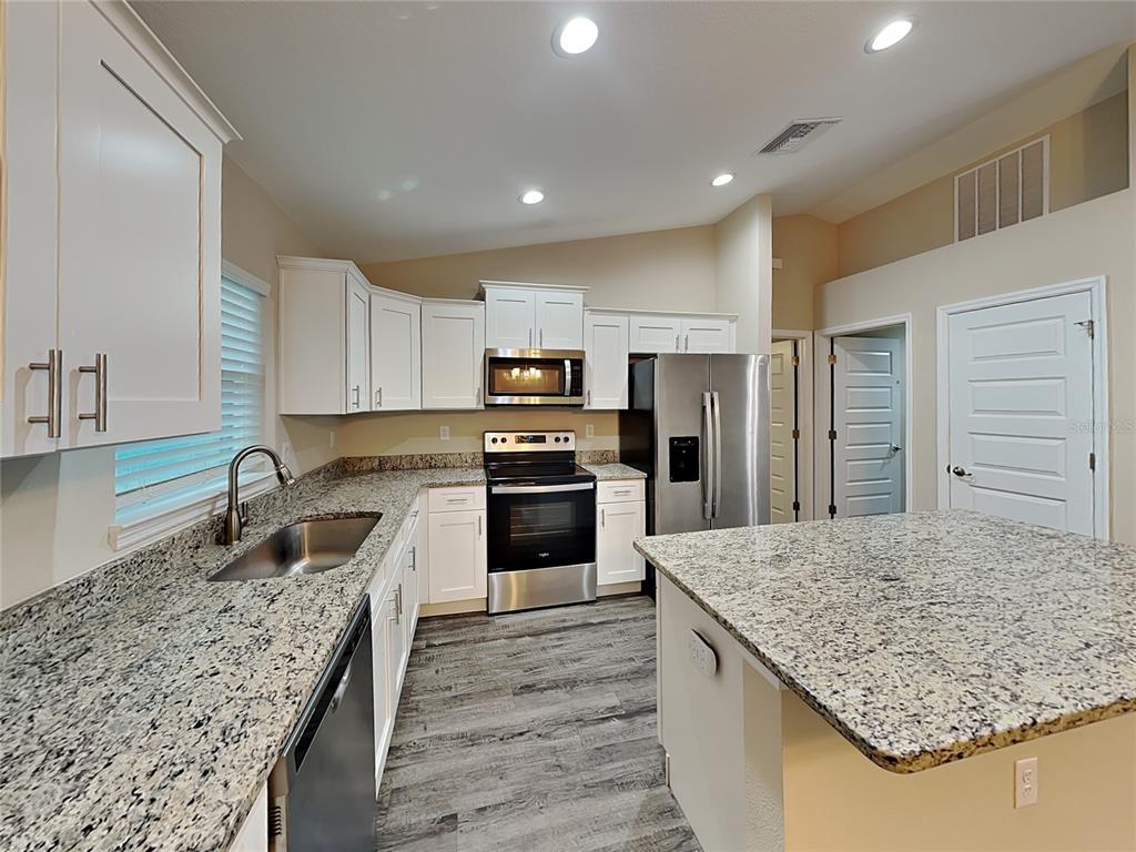 904 West Rum Place Dunnellon, FL 34434 - Photo 4 of 15 a kitchen with kitchen island granite countertop a sink stove and refrigerator