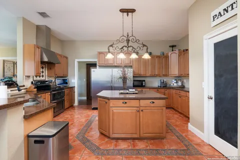 a kitchen with stainless steel appliances granite countertop a sink a stove and cabinets