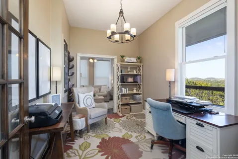 a living room with furniture a bookshelf and a window