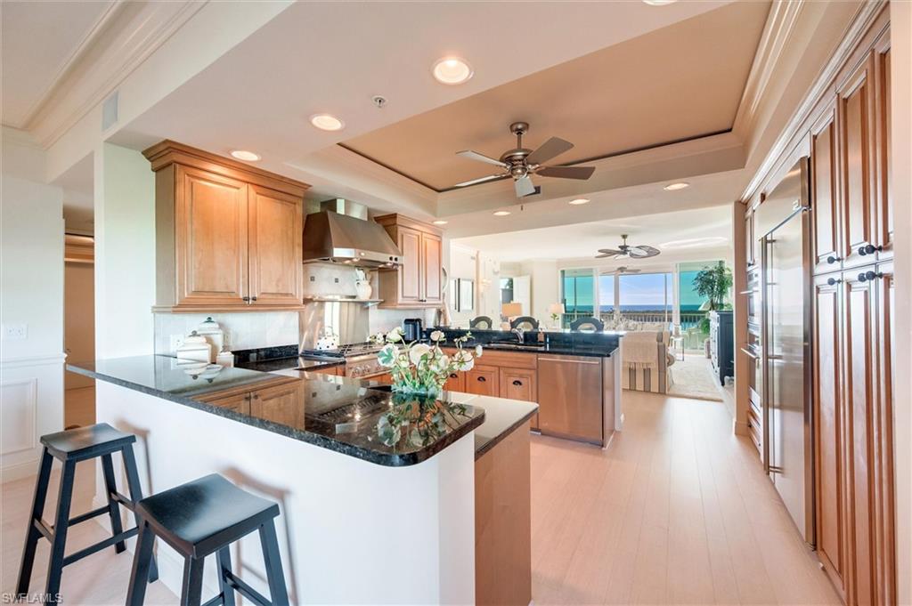 265 Indies Way, Unit 802 Naples, FL 34110 - Photo 14 of 50 a kitchen with a table chairs stove and refrigerator