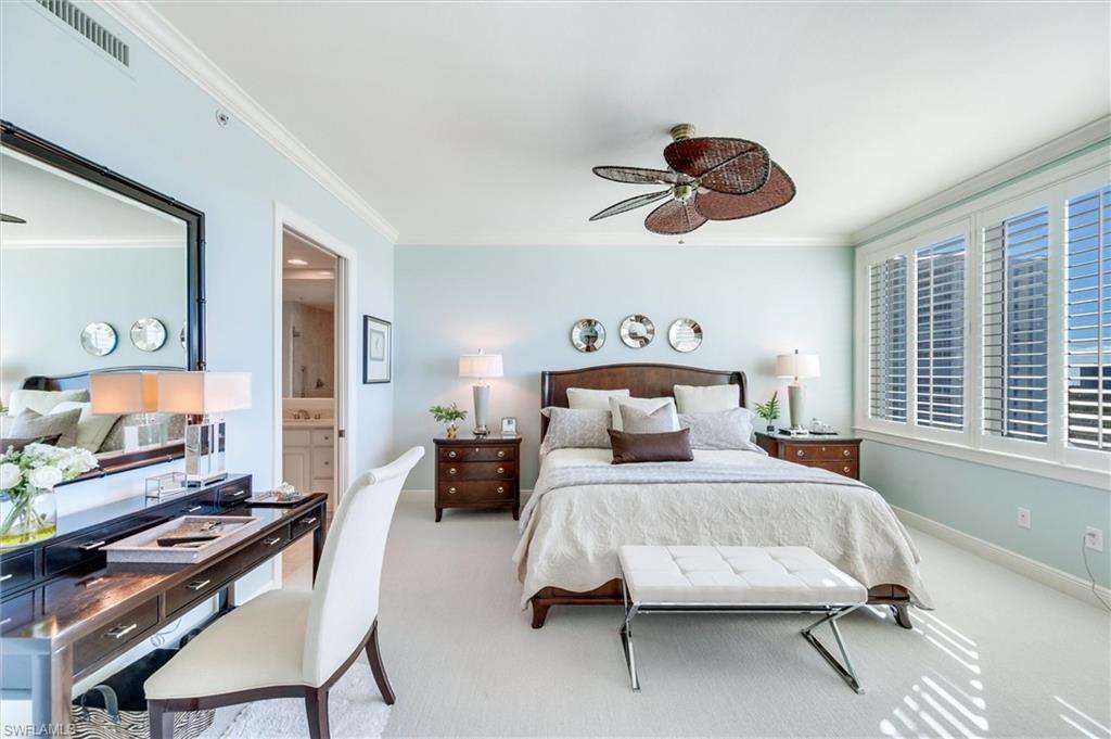 265 Indies Way, Unit 802 Naples, FL 34110 - Photo 21 of 50 a bedroom with a bed a chandelier and dresser