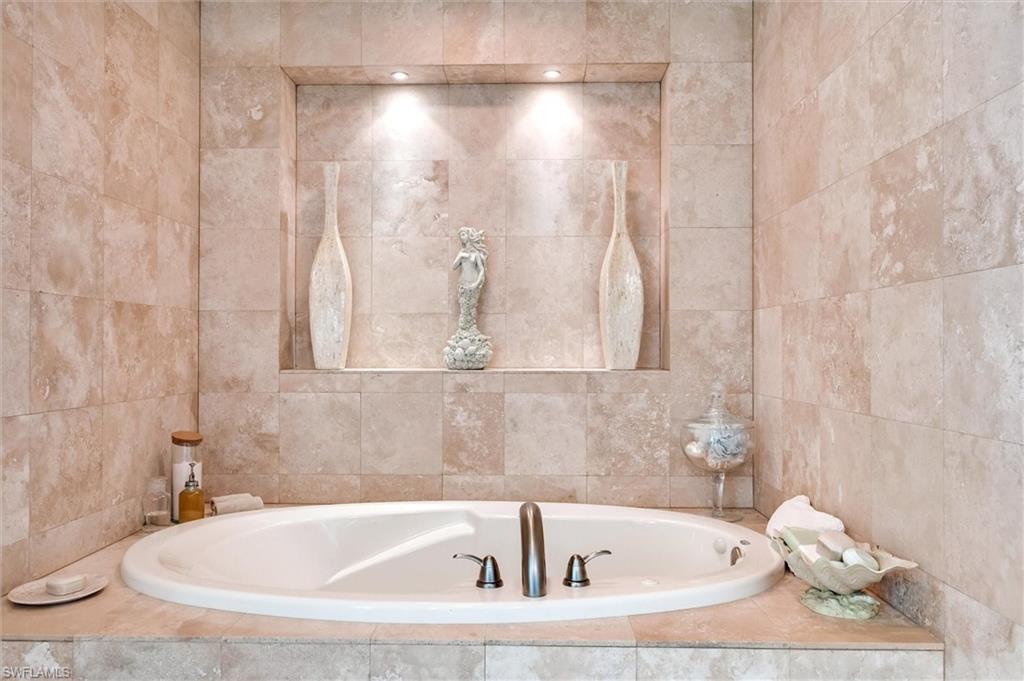 265 Indies Way, Unit 802 Naples, FL 34110 - Photo 24 of 50 a bathroom with a bathtub and a shower