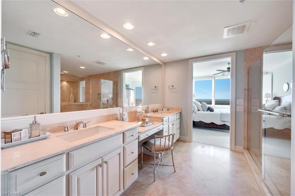 265 Indies Way, Unit 802 Naples, FL 34110 - Photo 25 of 50 a spacious bathroom with a granite countertop sink and a mirror