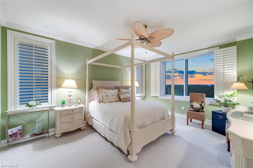 265 Indies Way, Unit 802 Naples, FL 34110 - Photo 29 of 50 a bedroom with a bed couch chandelier and a window