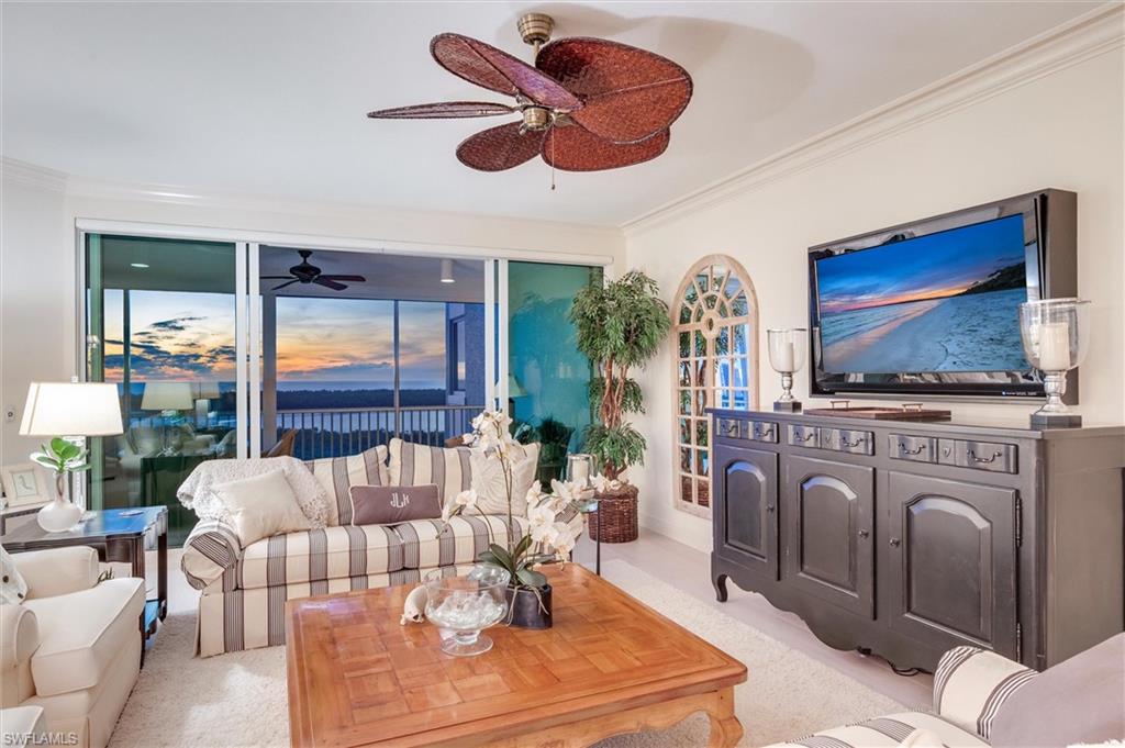 265 Indies Way, Unit 802 Naples, FL 34110 - Photo 6 of 50 a living room with furniture a flat screen tv and a fireplace