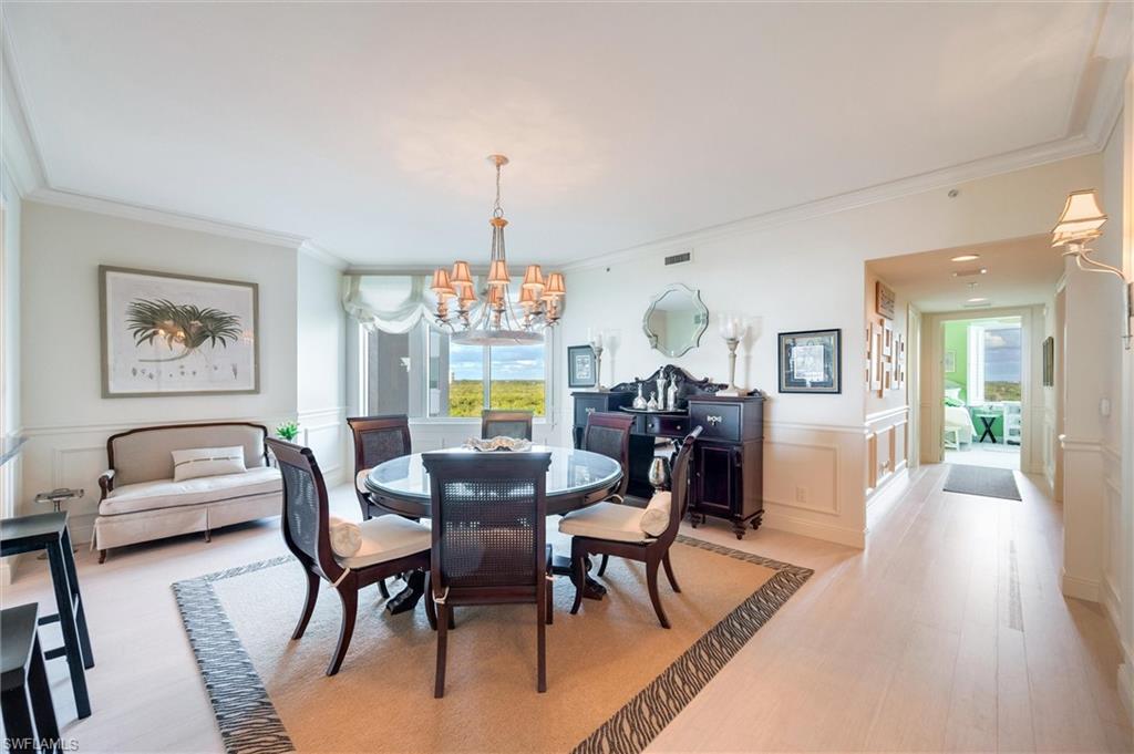 265 Indies Way, Unit 802 Naples, FL 34110 - Photo 10 of 50 a view of a dining room with furniture a chandelier and wooden floor