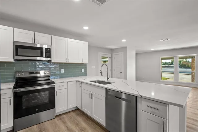 a kitchen with a sink stove and microwave
