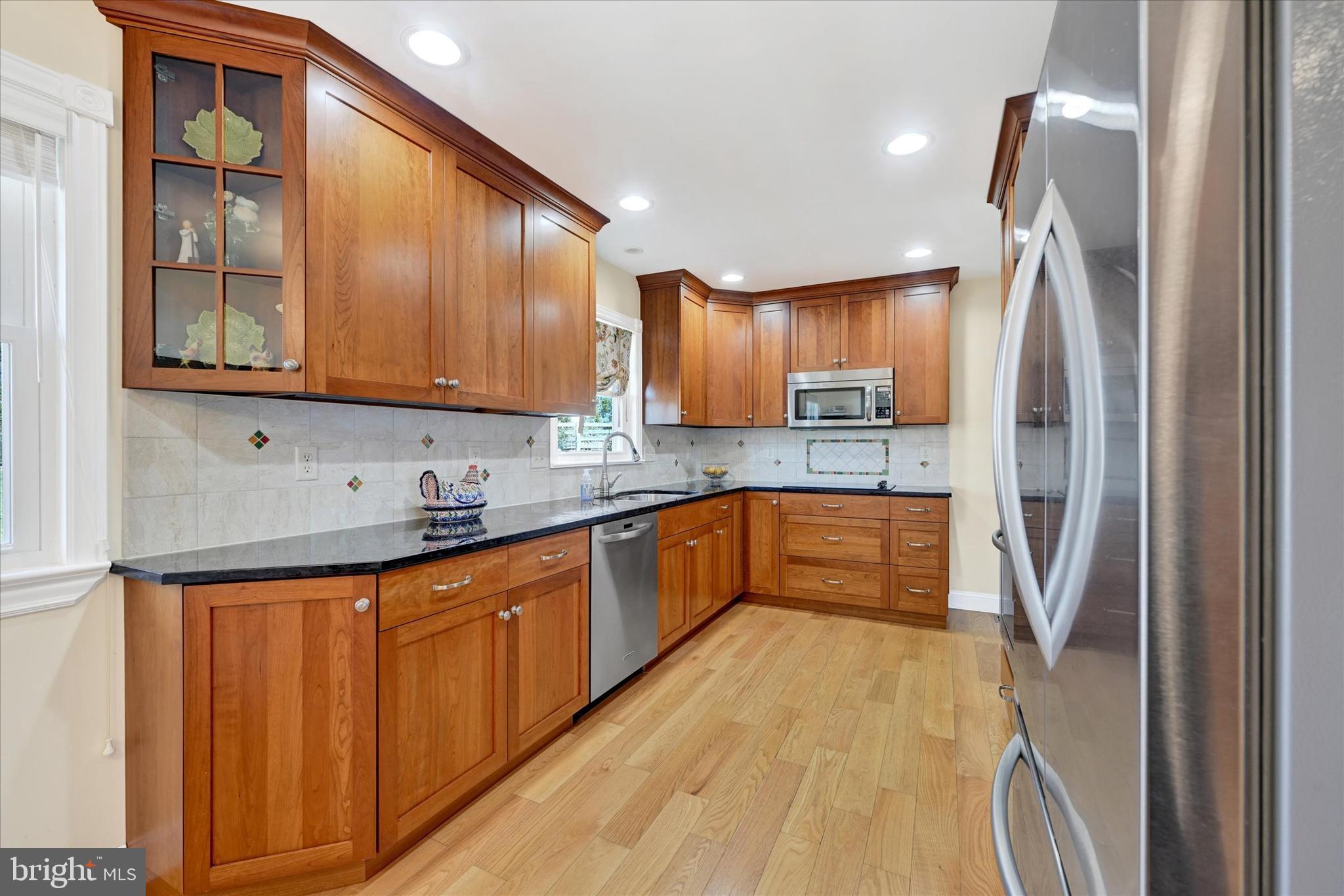 2524 Jennings Chapel Road Woodbine, MD 21797 - Photo 6 of 41 a kitchen with stainless steel appliances granite countertop a refrigerator a sink dishwasher and wooden cabinets with wooden floor