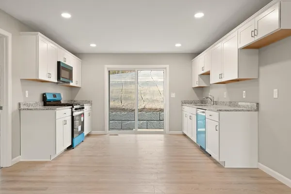 a kitchen with white cabinets and white appliances