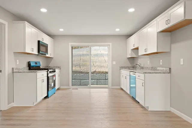 a kitchen with white cabinets and white appliances