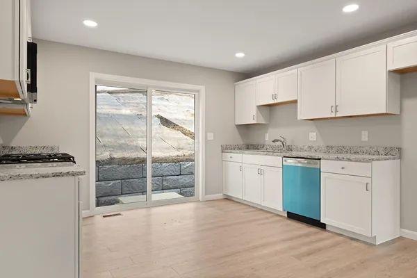 a kitchen with granite countertop a stove top oven sink and cabinets