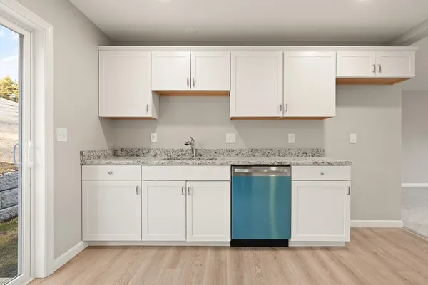 a kitchen with granite countertop white cabinets and a stainless steel appliances