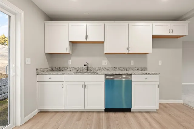 a kitchen with granite countertop white cabinets and a stainless steel appliances