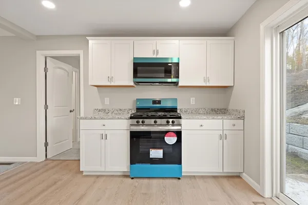 a kitchen with stainless steel appliances granite countertop a stove a sink and a refrigerator with wooden floors