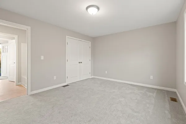 an empty room with closet and windows