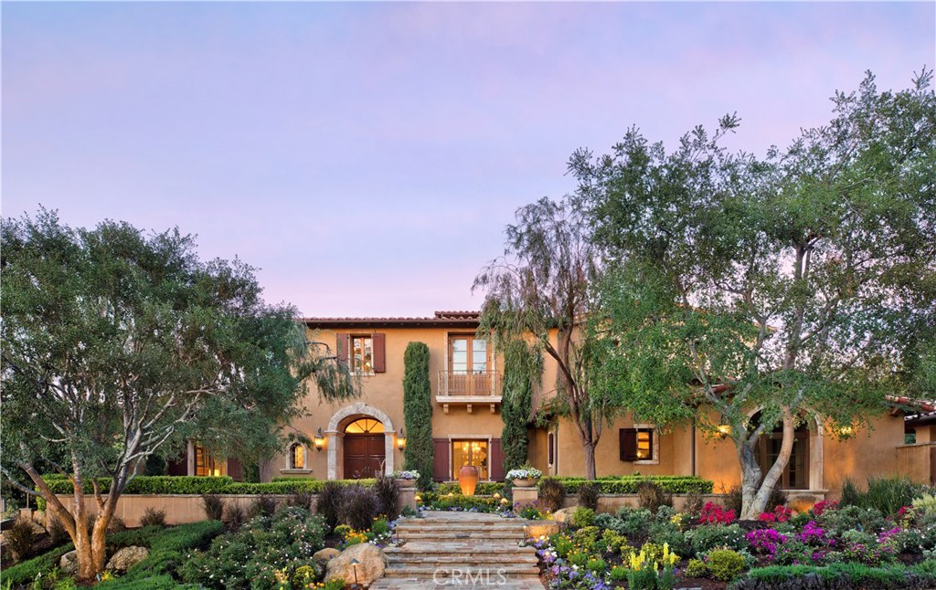 a front view of a house with a yard and fountain in middle