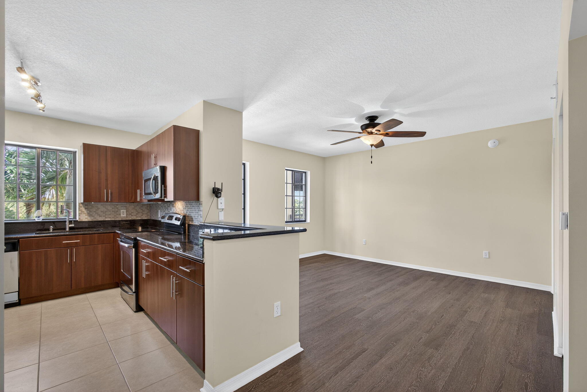 4907 Midtown Lane, Unit 1314 Palm Beach Gardens, FL 33418 - Photo 12 of 57 a kitchen with stainless steel appliances granite countertop a hardwood floor sink stove and granite counter top